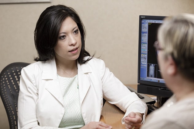 A physician in the Early Onset and Hereditary Gastrointestinal (GI) Cancers Program consults with a patient.