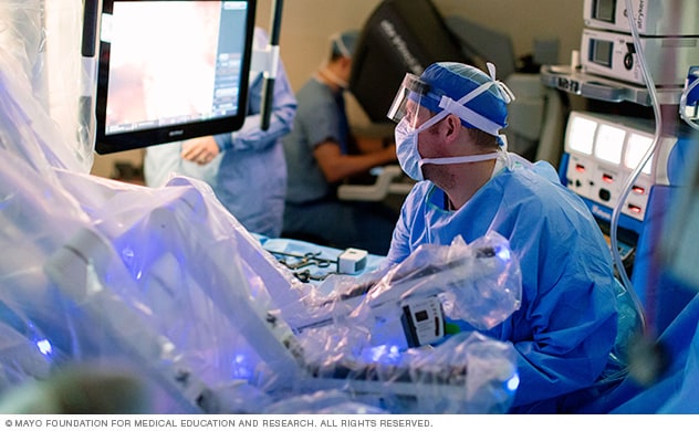A surgeon consults a surgical monitor.
